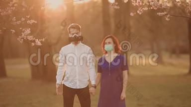 年轻夫妇戴着口罩站在里<strong>加</strong>樱花公园H1N1或冠状病毒流行期间看着你
